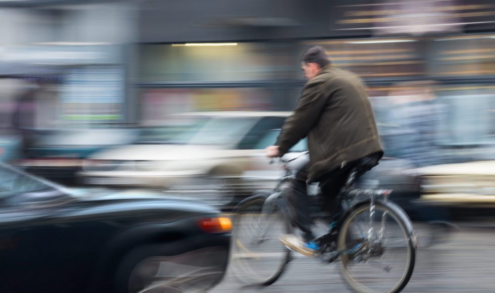 Dangerous city traffic situation with cyclist and car in the city in motion blur